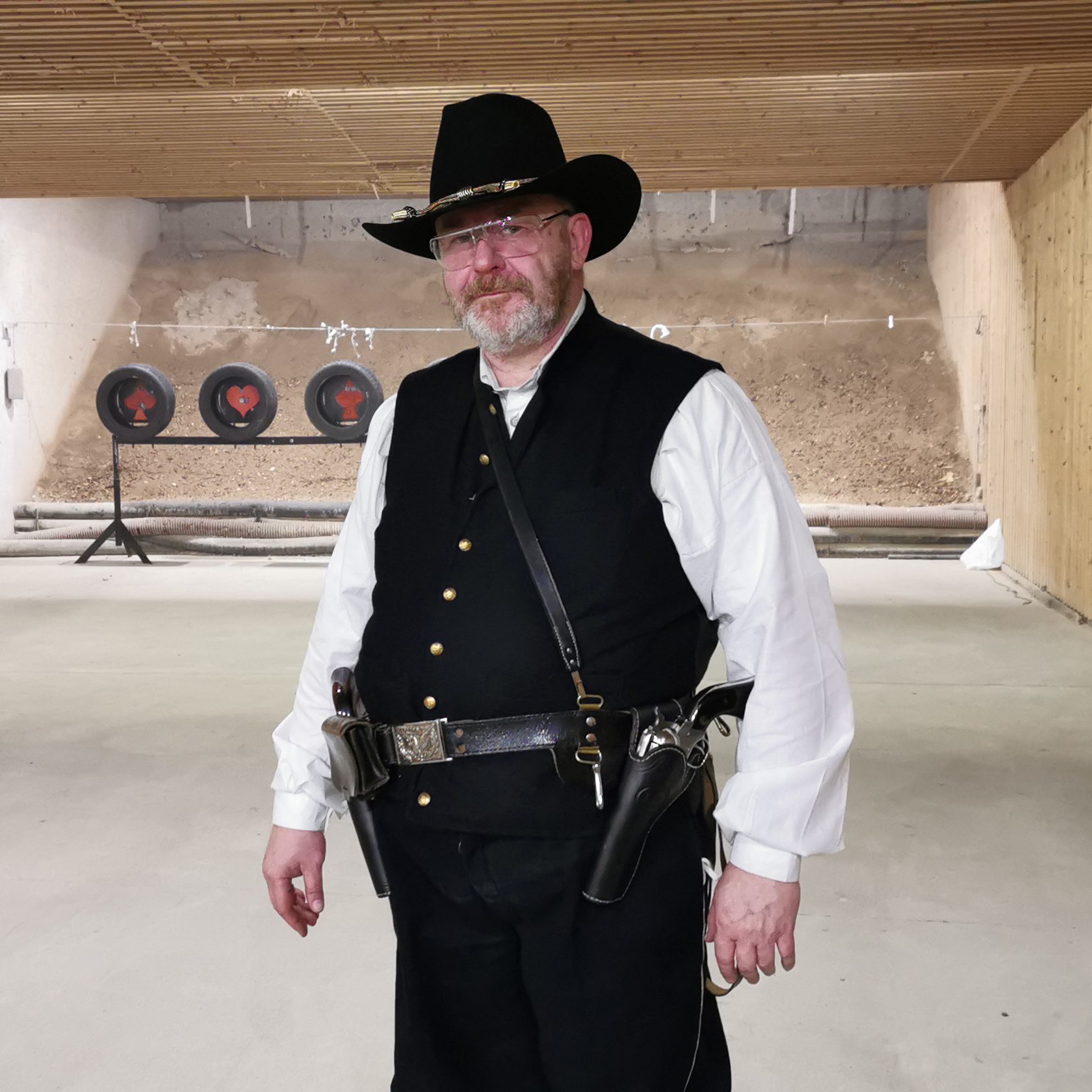 Cowboy-Action-Schütze in Weste und Westernhut auf dem Schießstand